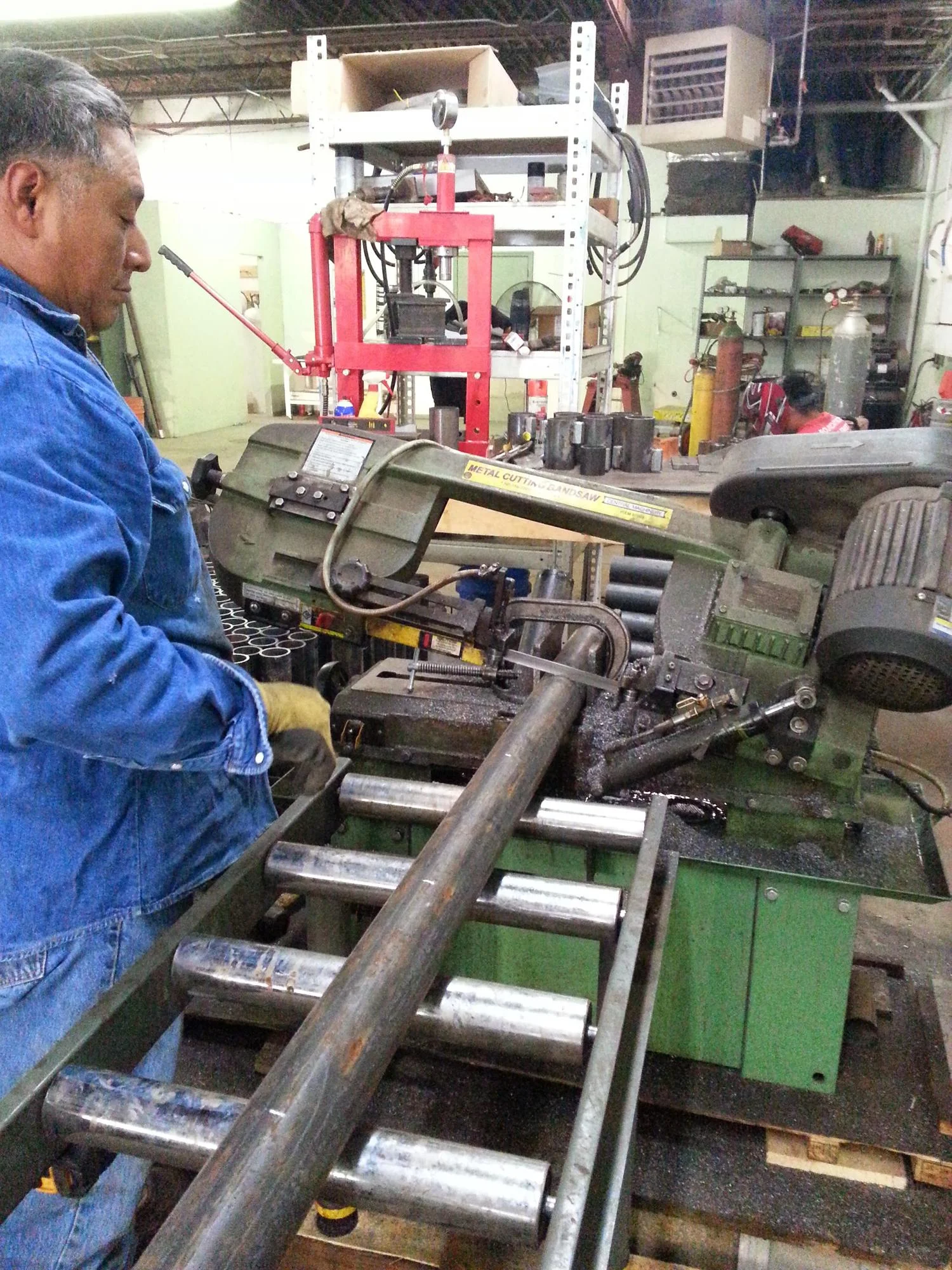 Technician operating industrial foundation repair press with hydraulic cylinders and control systems