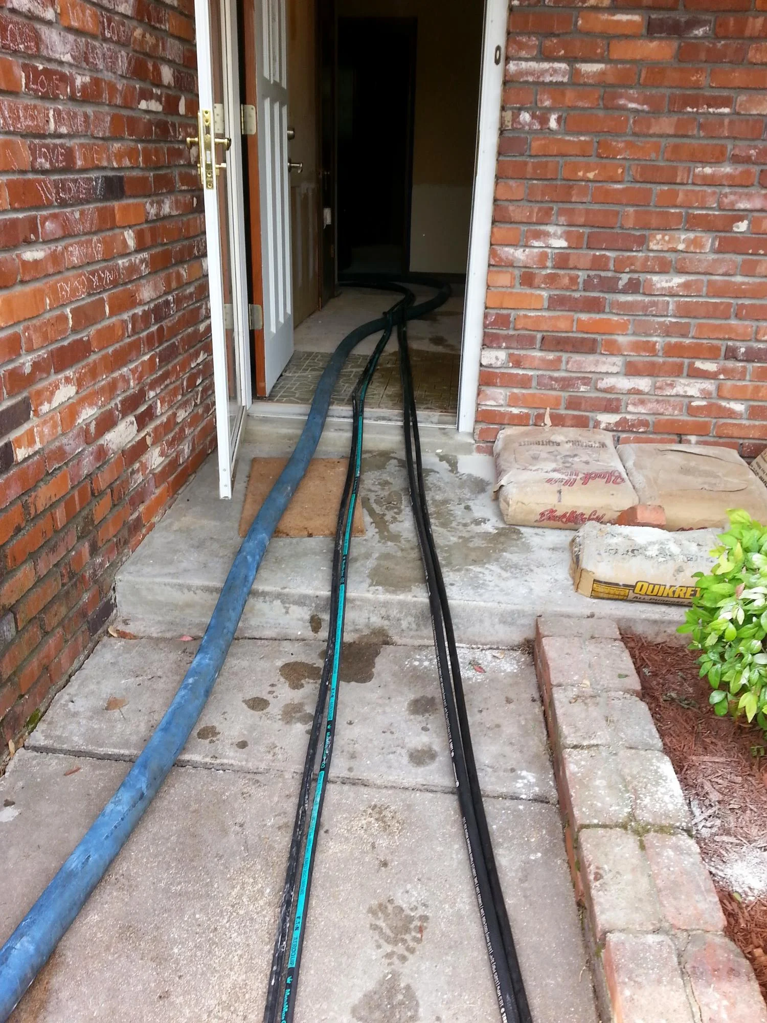 Hydraulic piering tubes installed under brick home foundation in Tulsa