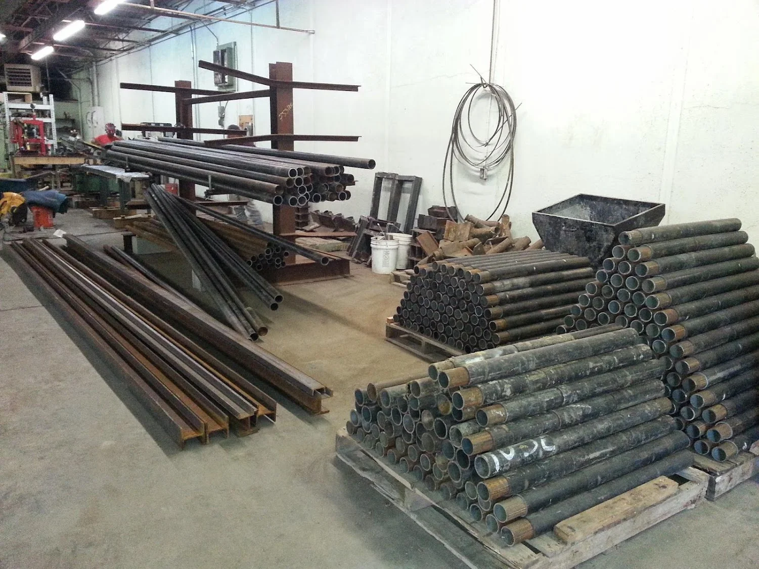 Steel pipes and piering materials organized in industrial workshop facility