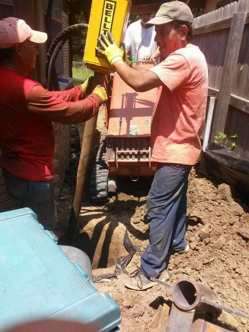 Foundation repair crew installing adjustable steel piers with hydraulic lift system